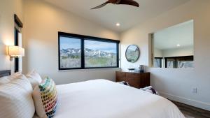 a bedroom with a white bed and a large window at Hilltop Chateau in Steamboat Springs +21 photos