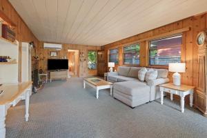 Una sala de estar con un sofá y un televisor. en Mirror Pond bungalow, en Bend