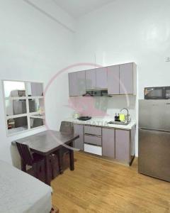 a kitchen with a table and a stainless steel refrigerator at Megatower 3 GF17 Baguio Condo by Dei Gratia in Baguio