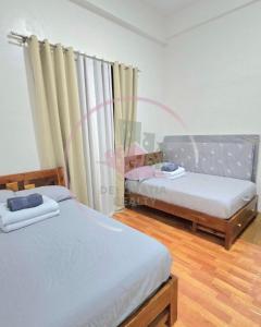 a bedroom with two beds and a window at Megatower 3 GF17 Baguio Condo by Dei Gratia in Baguio