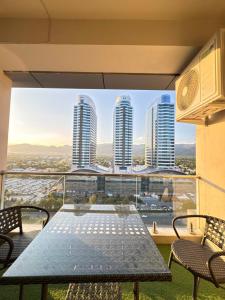 a table on a balcony with a view of skyscrapers at Elysium Premium Centaurus View in Islamabad