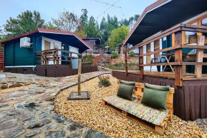a house with two pillows on a stone patio at Mimosa Village - Turismo de Natureza in Mortágua
