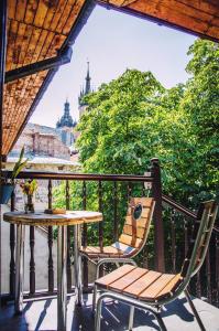 un tavolo e sedie su un balcone con vista sulla città di Hostel u Kmity a Cracovia