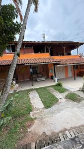 ein Haus mit einer Bank davor in der Unterkunft Hospedaria Oceania in Bombinhas + 33 Fotos