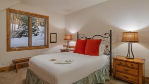 a bedroom with a bed with red pillows and a window at Inglenook in Breckenridge +19 photos