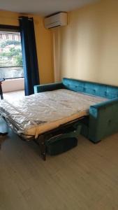 a bed in a room with a blue couch at 2 pieces chic avec une vue panoramique in Beausoleil