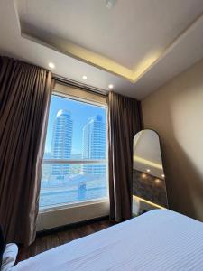 a bedroom with a large window with a view of a city at Elysium Premium Centaurus View in Islamabad