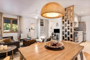 a living room with a wooden table and a kitchen at Boulder Grove Ranch on Acres of Boulders Plus Hot Tub in Yucca Valley