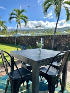 a table with chairs and a vase of flowers on it at Happy Hill Inn in Kailua-Kona