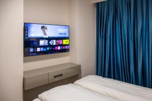 a bedroom with a bed and a flat screen tv at Deluxe Apartment in Bonn