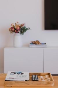 un tavolo con un libro e un vaso con fiori di Marea Alta a La Caleta