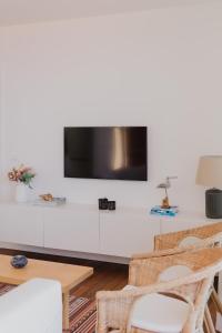 un soggiorno con TV su una parete bianca di Marea Alta a La Caleta
