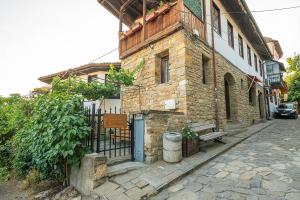 a stone building with a gate and a bench on a street at Apartment Zdravets 2, in the heart of the old city in Veliko Tŭrnovo
