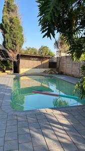 a swimming pool in the middle of a yard at Aneiwa airport lodge in Kempton Park