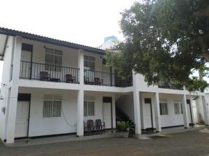 a large white building with chairs on the balconies at Romana Rest Kataragama in Kataragama