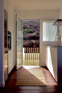 porta aperta a una cucina con vista su un balcone di Marea Alta a La Caleta Altre 12 foto