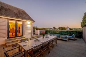a wooden deck with a table and chairs on a house at 5 Bed in Rock oc-m33185 in Padstow
