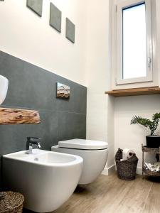 Un baño con un inodoro blanco y un lavabo. en Bucolocale, en Aosta 2 fotos más