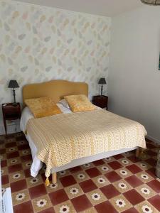 a bed with two pillows on it in a bedroom at Le Petit Moulin à 7 minutes du ZooParc de Beauval in Châteauvieux