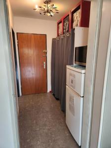 ein Flur, der zu einer Küche mit Kühlschrank und Tür führt in der Unterkunft Apartment Ferienwohnung modern nähe Altstadt Landshut in Landshut