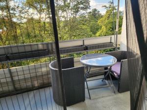 eine Terrasse mit Tisch und Stühlen auf einem Balkon in der Unterkunft Apartment Ferienwohnung modern nähe Altstadt Landshut in Landshut