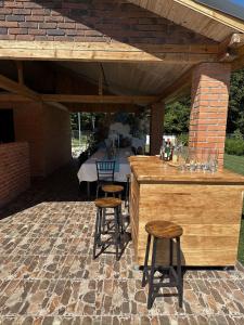 a patio with a bar with stools and a table at Cabana 1407 Valea Avrigului in Avrig