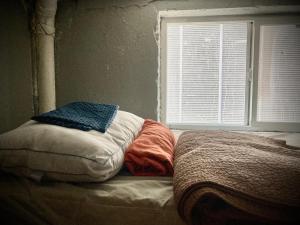 Una cama deshecha en una habitación con ventana en Artist Housing - Downtown, en Los Ángeles