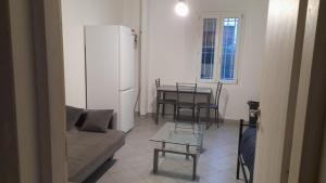 Una sala de estar con un sofá, una mesa y un refrigerador. en BBG app, en Bolonia
