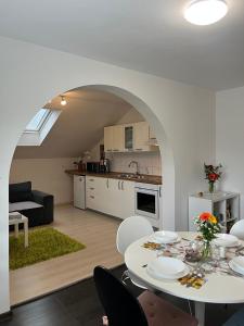 a kitchen and living room with a white table and chairs at Apartments Bukor with seasonal pool in Lukovica pri Domžalah