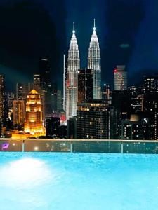 una piscina con vistas a la ciudad por la noche en The Luxe & Colony Infinitum KLCC by CoupleStay, en Kuala Lumpur