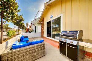 a outdoor patio with a grill and blue chairs at Balboa Duplex in Newport Beach +53 photos