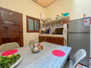 una cocina con una mesa y un refrigerador en AGADIR hay al FARAH, en Agadir