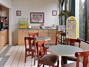 a restaurant with tables and chairs and a kitchen at Days Inn by Wyndham Hendersonville in Hendersonville