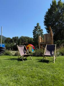 two folding chairs sitting on the grass in a field at Cabana 1407 Valea Avrigului in Avrig