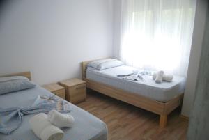 2 bedden in een kleine kamer met witte handdoeken bij Rezidenca Kalter Durres in Golem