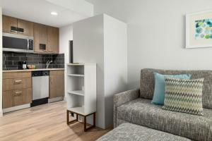 un salon avec un canapé et une cuisine dans l'établissement TownePlace Suites by Marriott Charlotte LoSo, à Charlotte