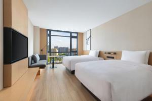 a hotel room with two beds and a flat screen tv at Fairfield by Marriott Wuhan Hankou in Wuhan