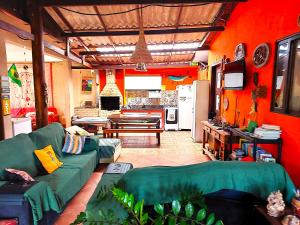 a living room with a green couch and a kitchen at Floripa Beach House Hostel in Florianópolis