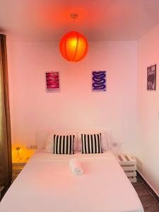 a bedroom with a large white bed with two pillows at Bright rooftop pool studio in Mtwapa, Fast Wi-Fi ,Free parking ,Near Beach in Mtwapa +11 photos
