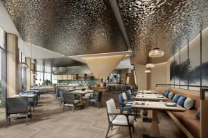 a restaurant with wooden tables and chairs and a ceiling with glitter at Fairfield by Marriott Qingdao West Coast in Qingdao
