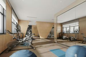 a gym with exercise bikes and a glass wall at Fairfield by Marriott Qingdao West Coast in Qingdao