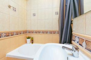 a bathroom with a sink and a bath tub at City Vibes Warsaw Sienna by P&M in Warsaw