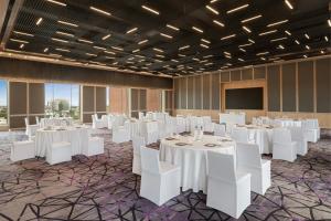 a banquet hall with white tables and white chairs at Marriott Executive Apartments Bengaluru UB City in Bengaluru +61 photos