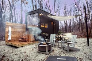 een tiny house met een grill en een tafel en stoelen bij Postcard Cabins Starved Rock, Outdoor Collection by Marriott Bonvoy in Ottawa