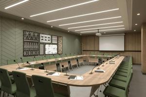 una gran sala de conferencias con una mesa larga y sillas verdes en Four Points by Sheraton Kinshasa, en Kinshasa