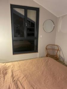 una camera da letto con una grande finestra e una sedia di Chambre dans maison individuelle 1 a Millau
