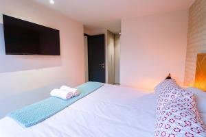 a bedroom with a white bed with towels on it at HOM I 2D2B Piscina Jacuzzi Estacionamiento Privado in Puerto Varas