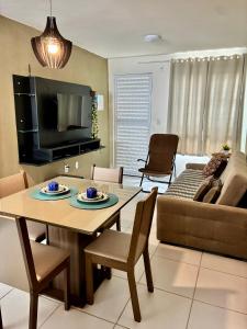 a living room with a table and a couch at Apartamento Beira Rio no Condomínio Brisas do Lago in Paulo Afonso