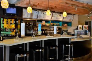 a bar with bar stools in a restaurant at Courtyard by Marriott Indianapolis South in Indianapolis