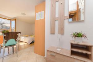 a living room with a bed and a table and a chair at House Hidden Beauty in Tribunj